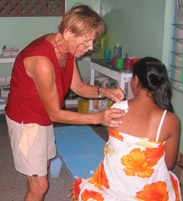 Palms Australia volunteer Marietje treating a sick student in Kiribati