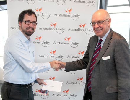 Brendan accepts the cheque from Alan Castleman, Chairperson of Australian Unity Foundation