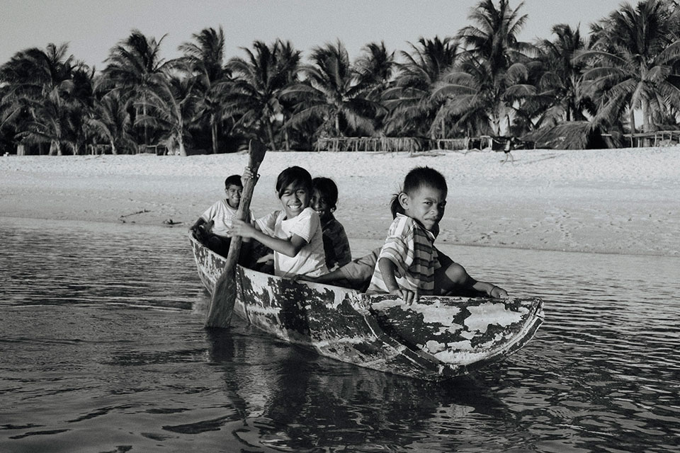 Black and white photo of children in canoe in Indonesia
