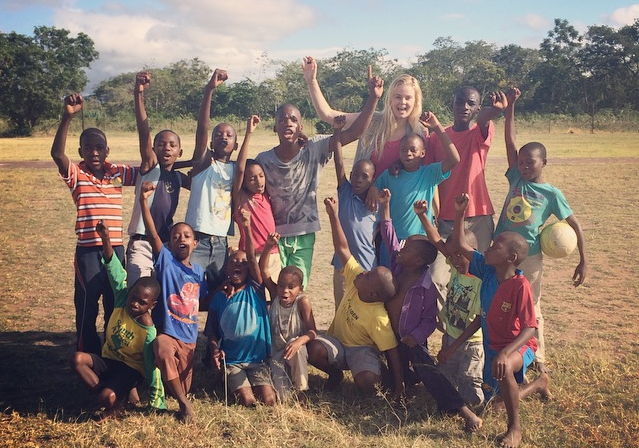 Volunteer in South Africa with local children with their hands in the air