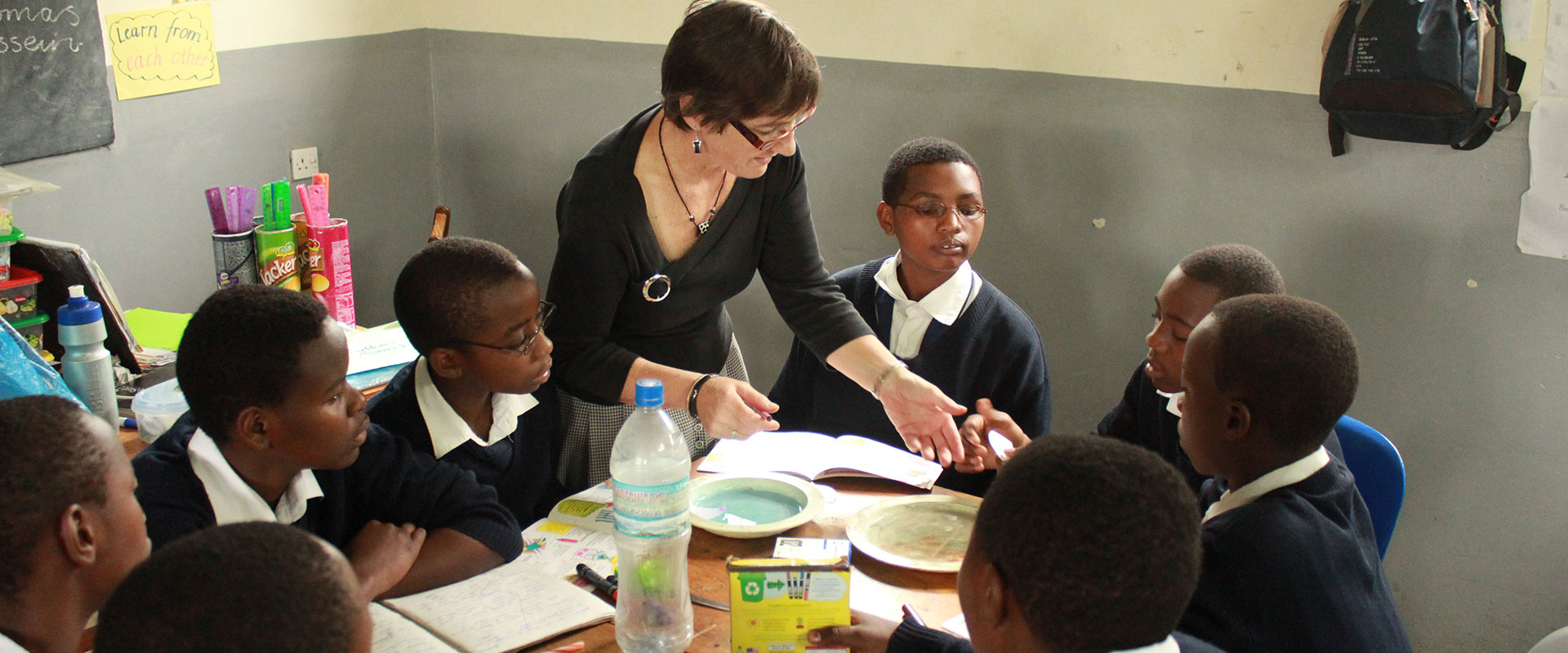 Volunteer teacher with young male students in South Africa