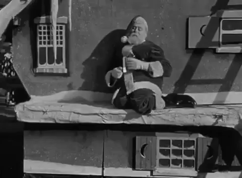 Santa Claus sitting against a wall drinking beer, woman slaps it out of his hand