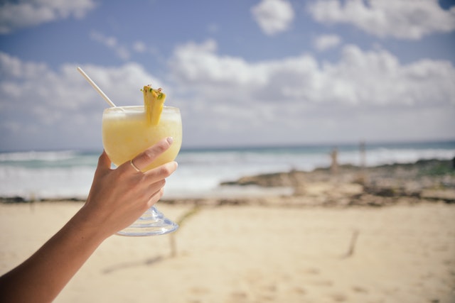 Hand holding a cocktail at the beach