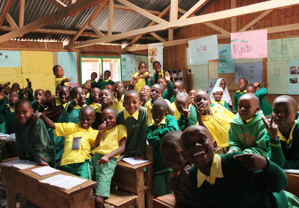 Children smiling in their classroom at Ruben Centre