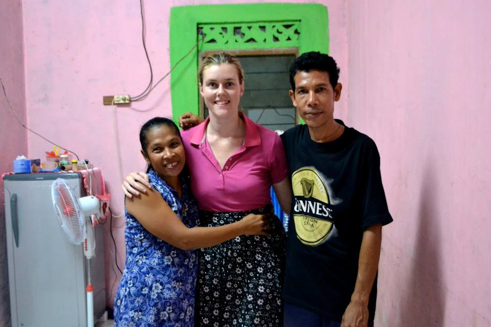 Encounter participant in Timor-Leste with arms around two local friends.