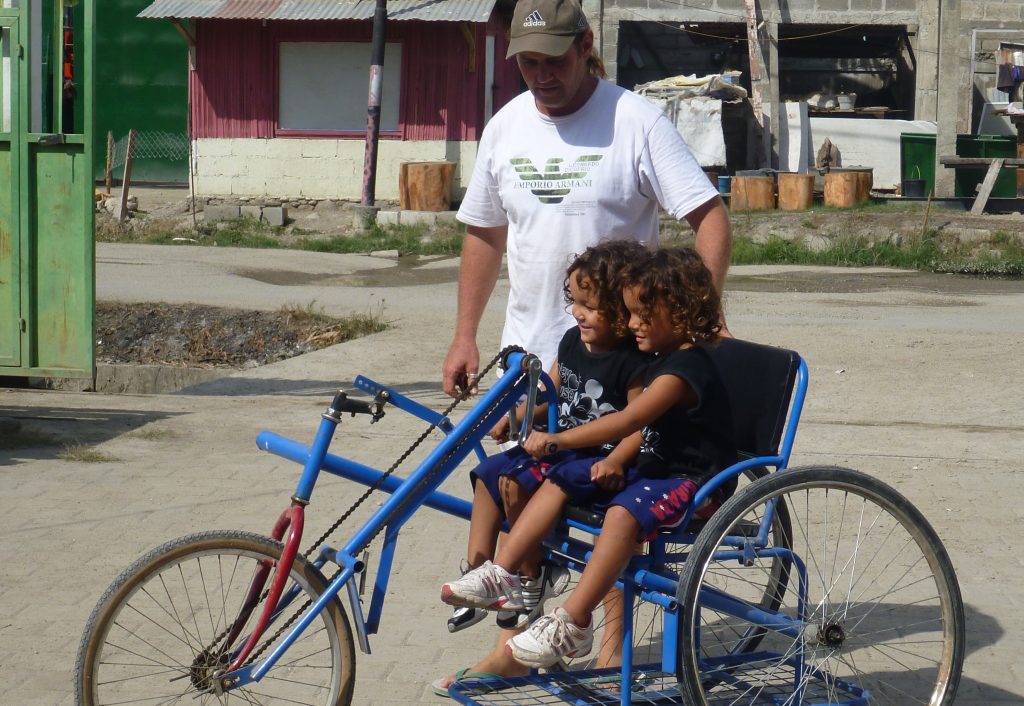 Barry Hinton and his two young sons riding a bike in Timor-Leste