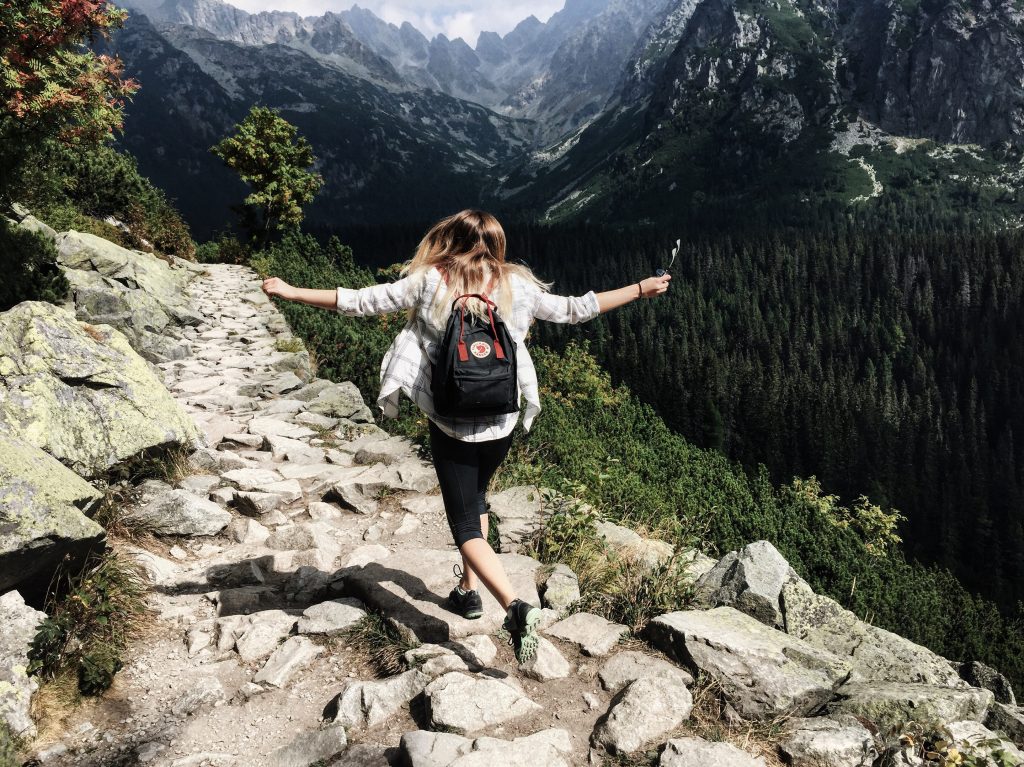 Girl jumping on a rocky mountain