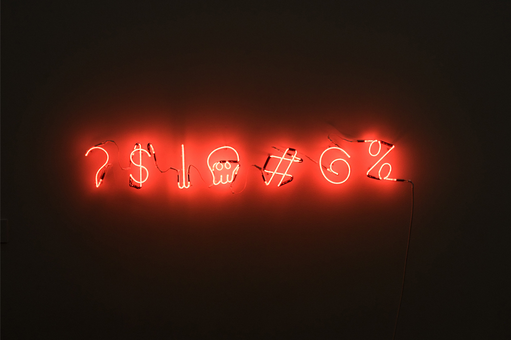Red neon symbols against a dark wall