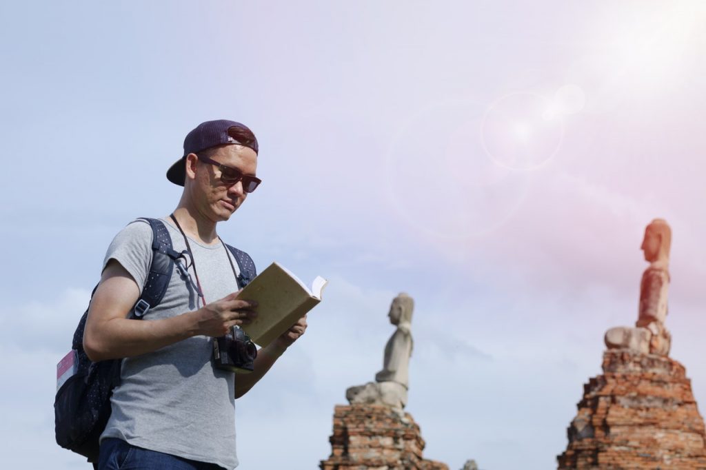 Young man with camera and guidebook