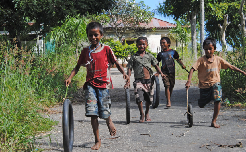 Children playing with wheels in Balibo